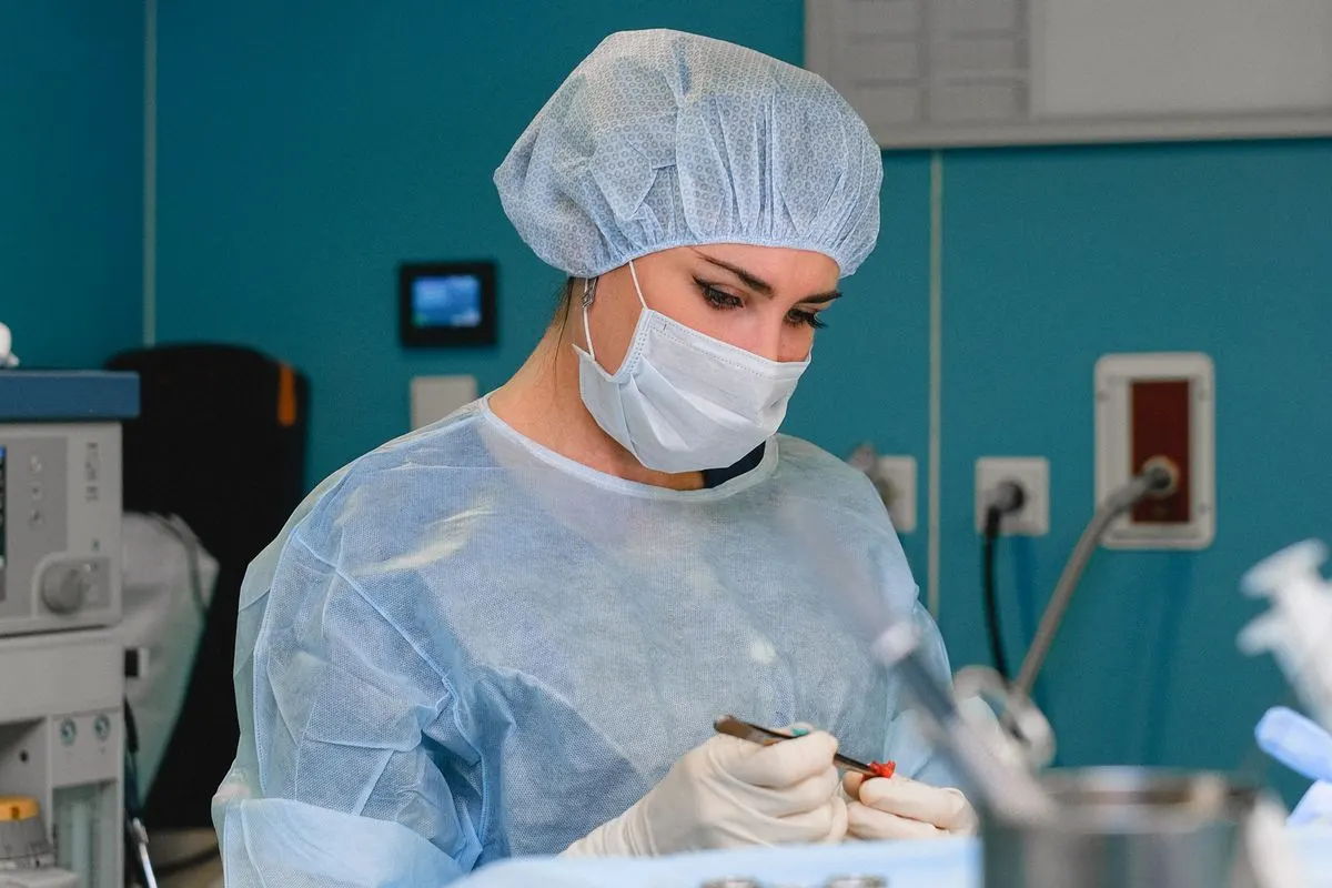 Spécialiste en tenue de protection maniant des instruments lors d'une greffe de cheveux FUE manuelle